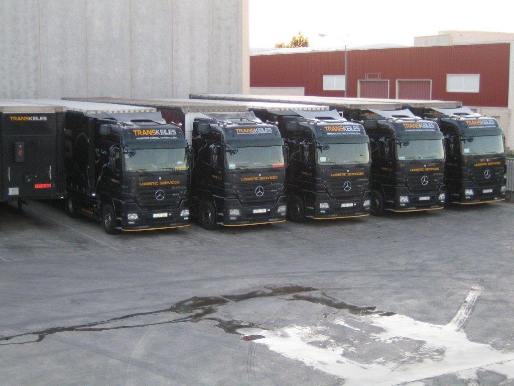 Tractoras negras de Transkeiles aparcadas en fila ante una nave